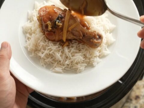 Glazed chicken drumsticks in a slow cooker with ginger and scallions in a sticky sauce