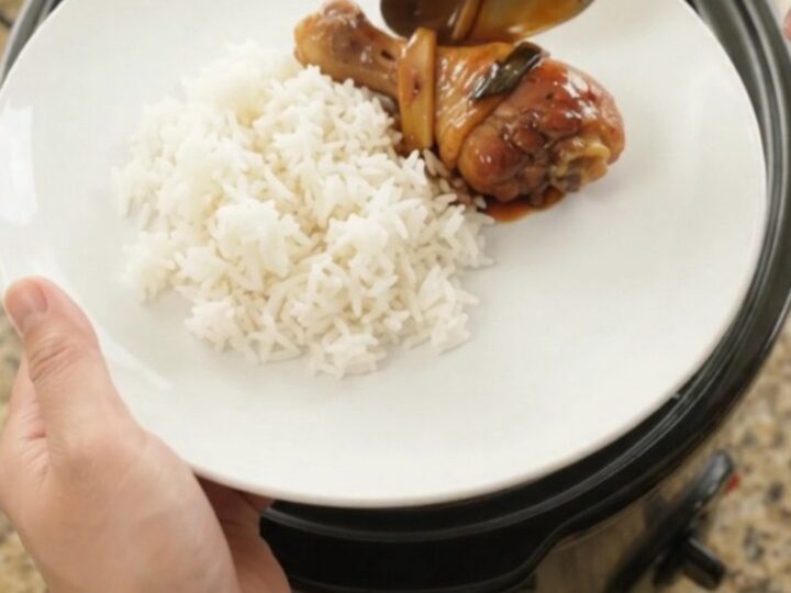 Slow-cooker chicken drumsticks glazed in hickory BBQ sauce with ginger and scallions, served on a white plate