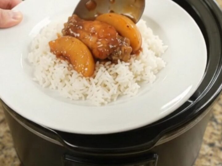 Slow cooker chicken wings with peaches and BBQ sauce, glistening in the pot