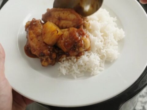 Slow cooker full of sticky BBQ chicken wings and caramelized pineapple