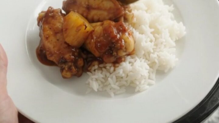 Slow cooker full of sticky BBQ chicken wings and caramelized pineapple