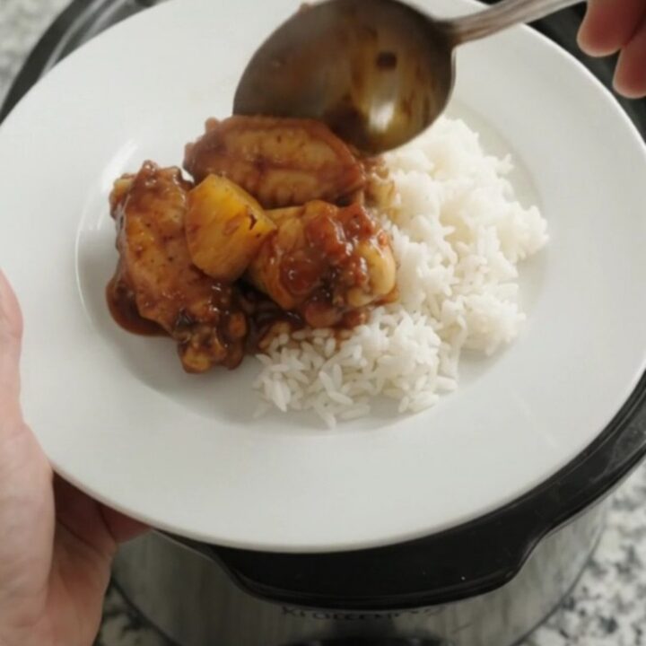 Slow cooker full of sticky BBQ chicken wings and caramelized pineapple