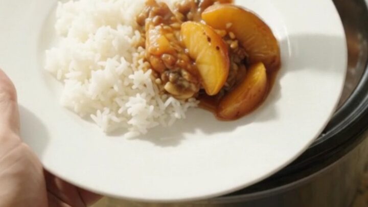 Glazed chicken wings and peach slices in a slow cooker with teriyaki sauce