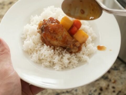 Slow cooker chicken wings in glossy mango hickory BBQ sauce with mango and red pepper