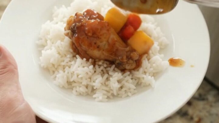 Slow cooker chicken wings in glossy mango hickory BBQ sauce with mango and red pepper