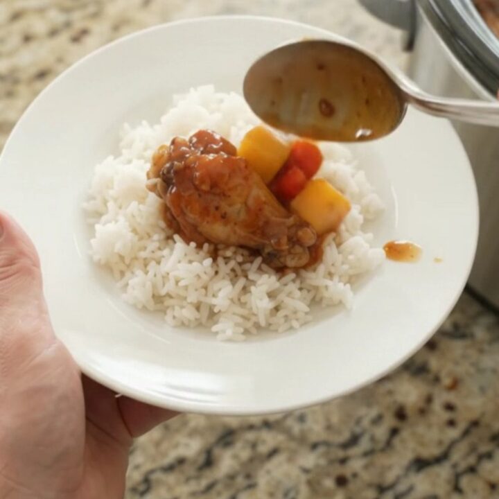 Slow cooker chicken wings in glossy mango hickory BBQ sauce with mango and red pepper