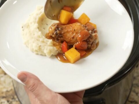 Sticky mango bourbon glazed chicken wings in a slow cooker with mango and red pepper