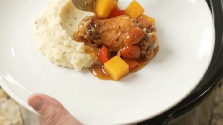 Sticky mango bourbon glazed chicken wings in a slow cooker with mango and red pepper