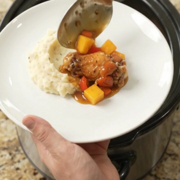 Sticky mango bourbon glazed chicken wings in a slow cooker with mango and red pepper