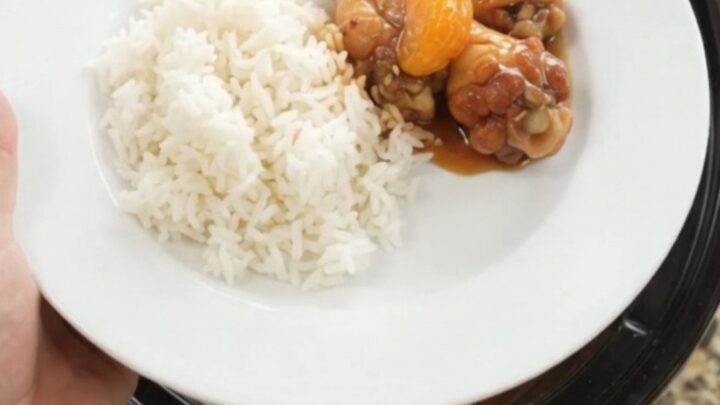 Sticky teriyaki chicken wings with mandarin oranges in a slow cooker, garnished with sesame seeds
