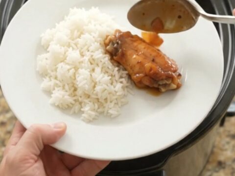 Sticky apricot hickory BBQ chicken wings in a slow cooker, glistening with dark sauce