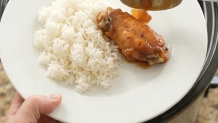 Sticky apricot hickory BBQ chicken wings in a slow cooker, glistening with dark sauce