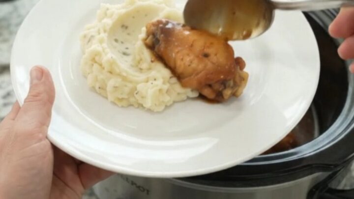 Sticky mandarin bourbon glazed chicken wings in a slow cooker, coated in glossy sauce with orange segments