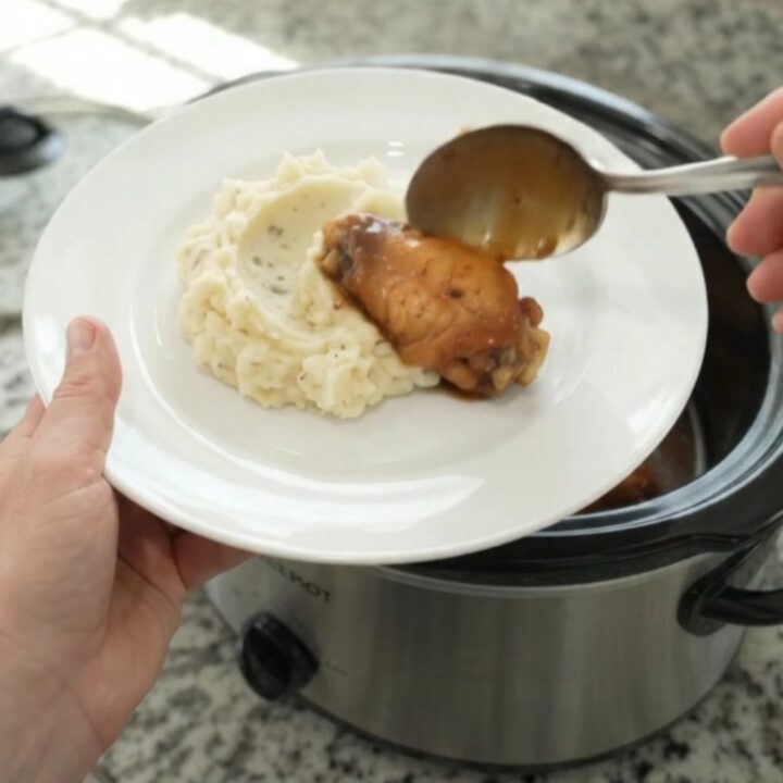 Sticky mandarin bourbon glazed chicken wings in a slow cooker, coated in glossy sauce with orange segments