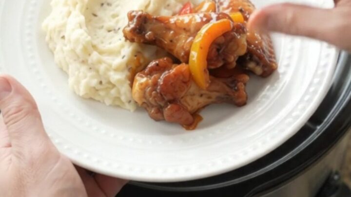 Slow cooker bourbon glazed chicken wings with bell peppers in a black crockpot