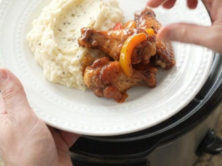 Slow cooker bourbon glazed chicken wings with bell peppers in a black crockpot