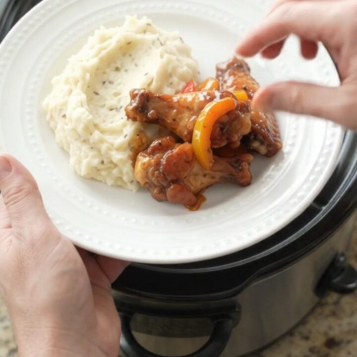 Slow cooker bourbon glazed chicken wings with bell peppers in a black crockpot