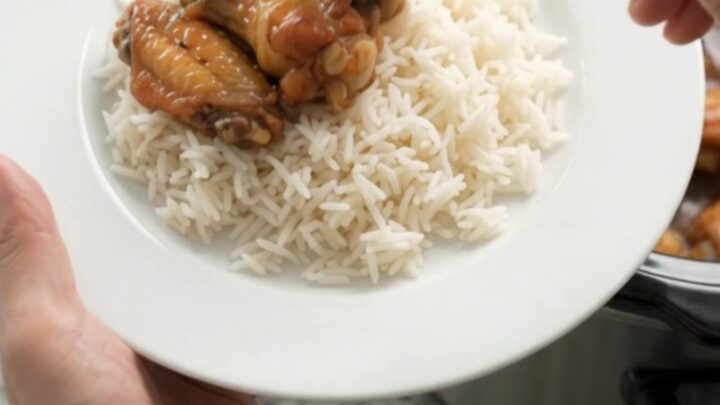 Sticky honey soy chicken wings in a slow cooker with garlic cloves and scallions