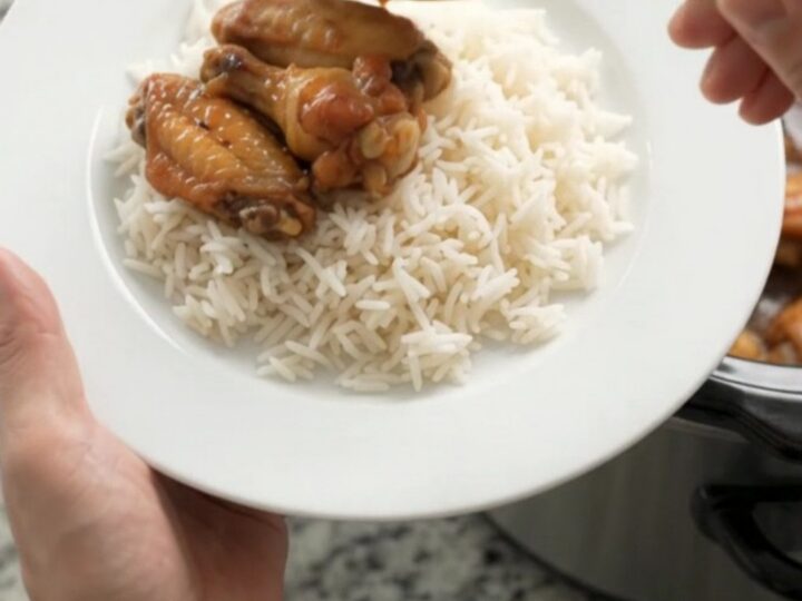 Sticky honey soy chicken wings in a slow cooker with garlic cloves and scallions