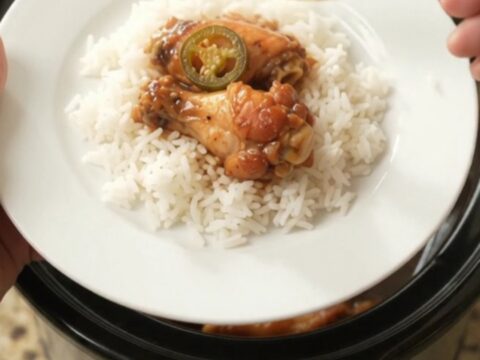 Slow cooker chicken wings in a glossy hickory BBQ sauce with pineapple and jalapeño rings