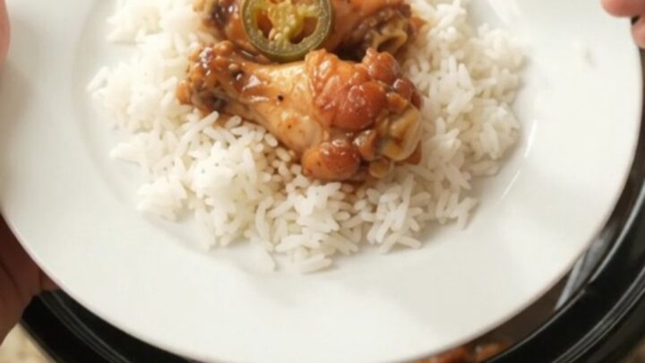 Slow cooker chicken wings in a glossy hickory BBQ sauce with pineapple and jalapeño rings