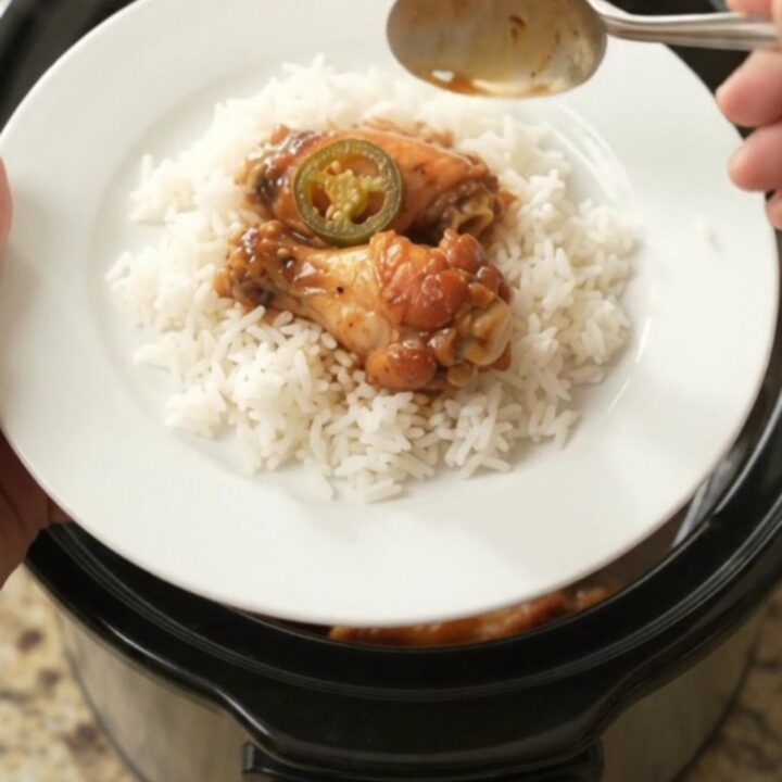 Slow cooker chicken wings in a glossy hickory BBQ sauce with pineapple and jalapeño rings