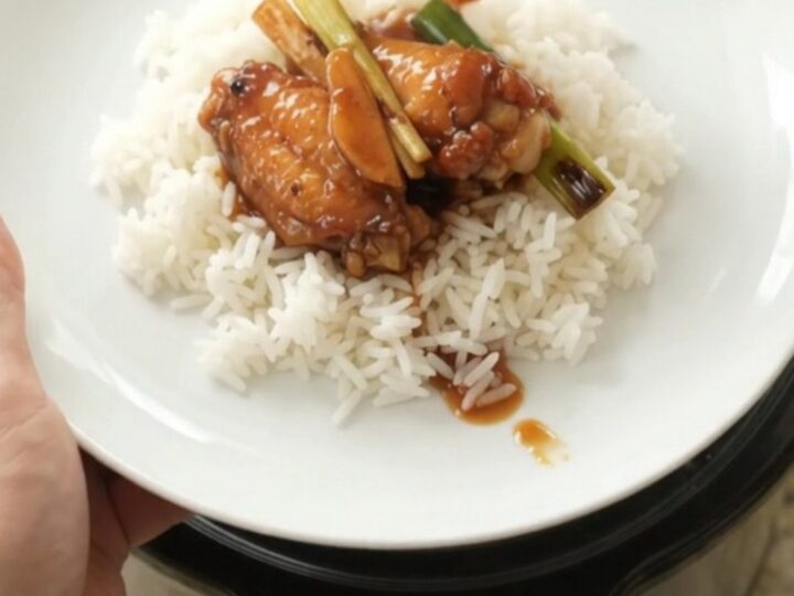 Slow cooker hickory BBQ chicken wings with ginger and scallions in a black crockpot