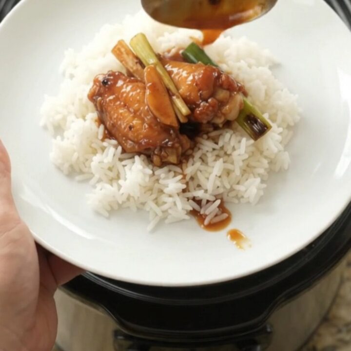 Slow cooker hickory BBQ chicken wings with ginger and scallions in a black crockpot