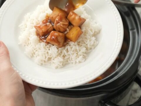Slow cooker filled with glazed chicken and pineapple chunks in hickory BBQ sauce