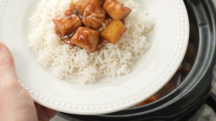 Slow cooker filled with glazed chicken and pineapple chunks in hickory BBQ sauce