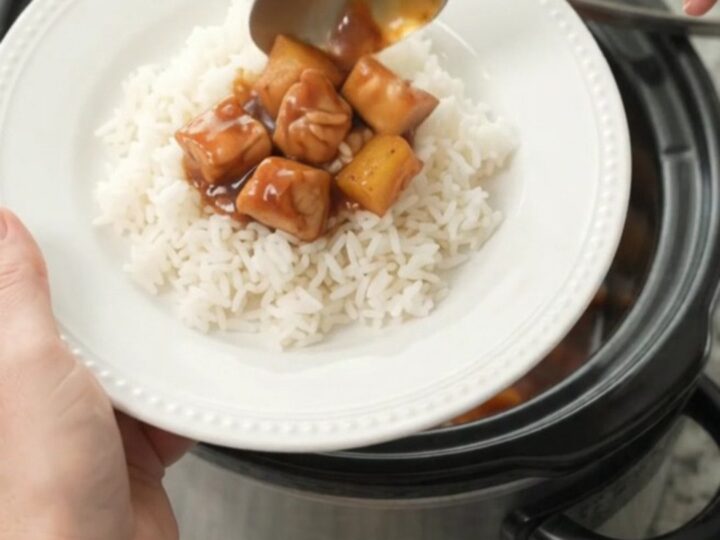 Slow cooker filled with glazed chicken and pineapple chunks in hickory BBQ sauce