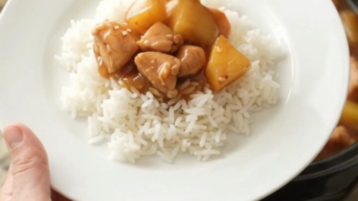 Crockpot teriyaki chicken bites with pineapple in a glossy sauce, served over rice