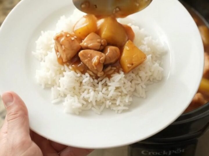 Crockpot teriyaki chicken bites with pineapple in a glossy sauce, served over rice