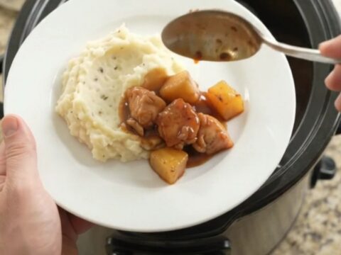 Slow cooker pineapple bourbon glazed chicken bites in a glossy sauce with caramelized pineapple chunks.