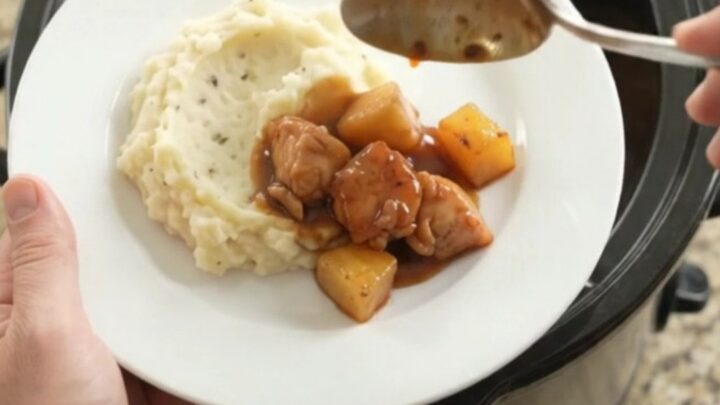 Slow cooker pineapple bourbon glazed chicken bites in a glossy sauce with caramelized pineapple chunks.