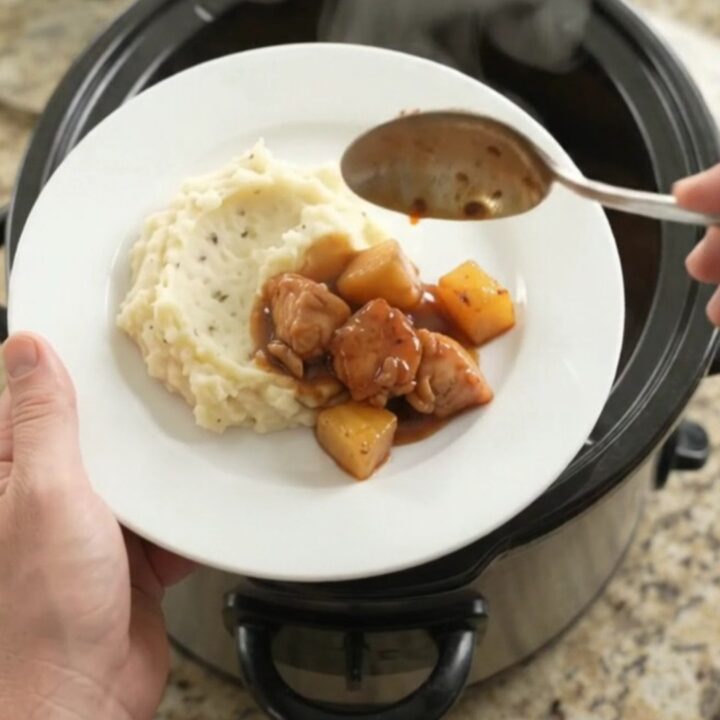 Slow cooker pineapple bourbon glazed chicken bites in a glossy sauce with caramelized pineapple chunks.