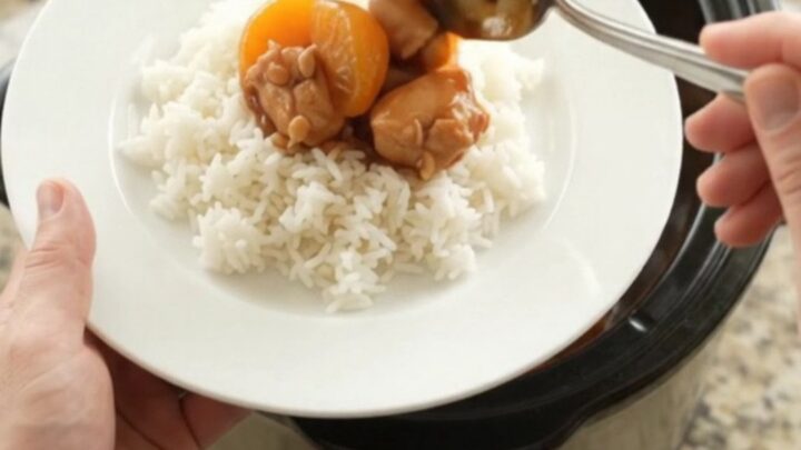 Slow cooker filled with glazed chicken bites and mandarin oranges in hickory BBQ sauce