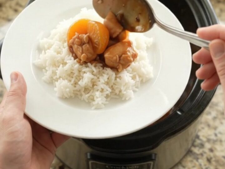 Slow cooker filled with glazed chicken bites and mandarin oranges in hickory BBQ sauce