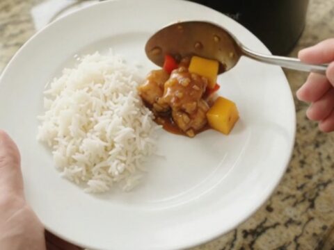 Crockpot mango honey soy chicken bites in a slow cooker, glistening with sticky amber sauce and topped with mango cubes