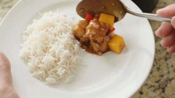 Crockpot mango honey soy chicken bites in a slow cooker, glistening with sticky amber sauce and topped with mango cubes