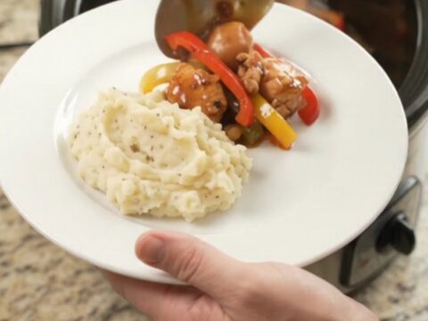 Slow cooker bourbon glazed chicken bites with bell peppers in a glossy sauce
