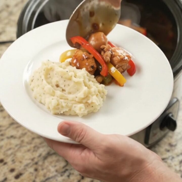 Slow cooker bourbon glazed chicken bites with bell peppers in a glossy sauce