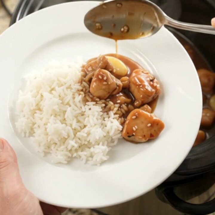 Slow cooker teriyaki chicken bites with garlic and scallions, glazed and glossy in the pot