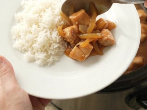 Glossy apricot teriyaki chicken bites in a slow cooker with sesame seeds and sauce