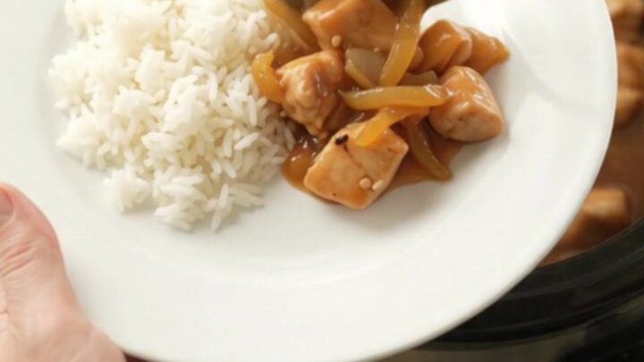 Glossy apricot teriyaki chicken bites in a slow cooker with sesame seeds and sauce