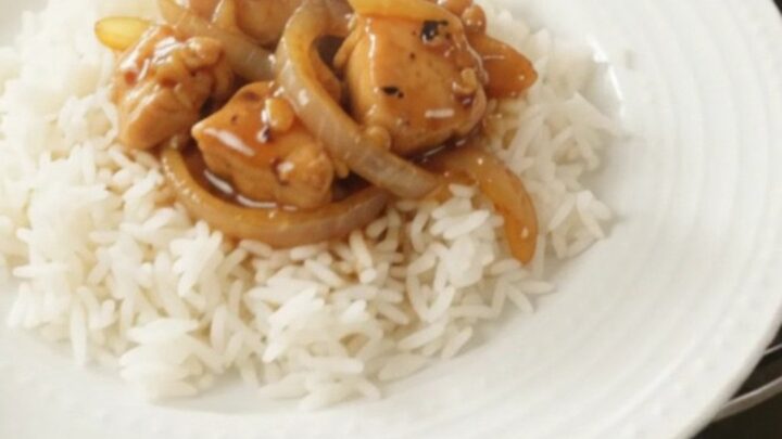 Glazed chicken bites and caramelized onions in a slow cooker with a glossy honey-soy sauce.