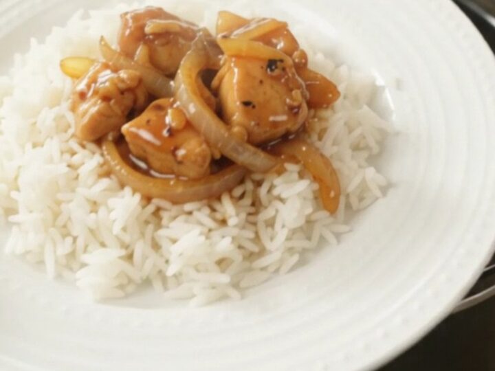 Glazed chicken bites and caramelized onions in a slow cooker with a glossy honey-soy sauce.