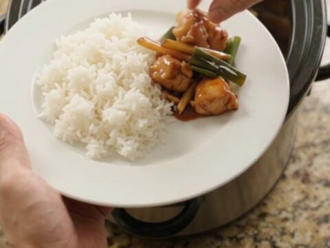 Slow-cooker chicken bites in glossy hickory BBQ sauce with ginger and scallions, served over jasmine rice