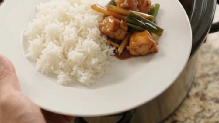 Slow-cooker chicken bites in glossy hickory BBQ sauce with ginger and scallions, served over jasmine rice