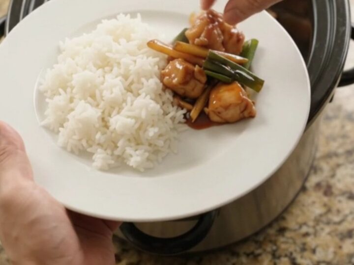 Slow-cooker chicken bites in glossy hickory BBQ sauce with ginger and scallions, served over jasmine rice
